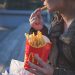 Kvinne som spiser pomme frites