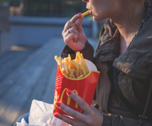 Kvinne som spiser pomme frites