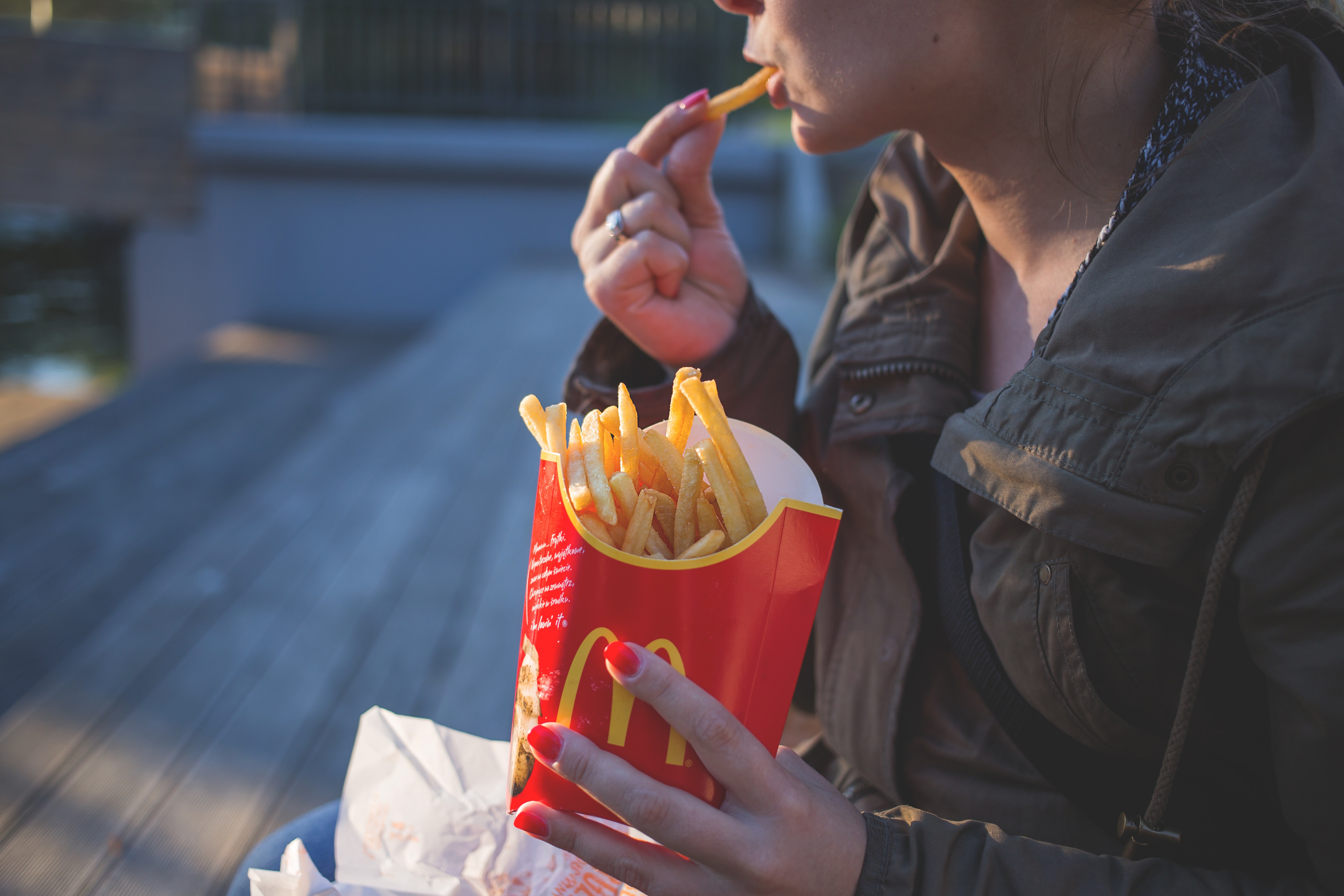 Kvinne som spiser pomme frites